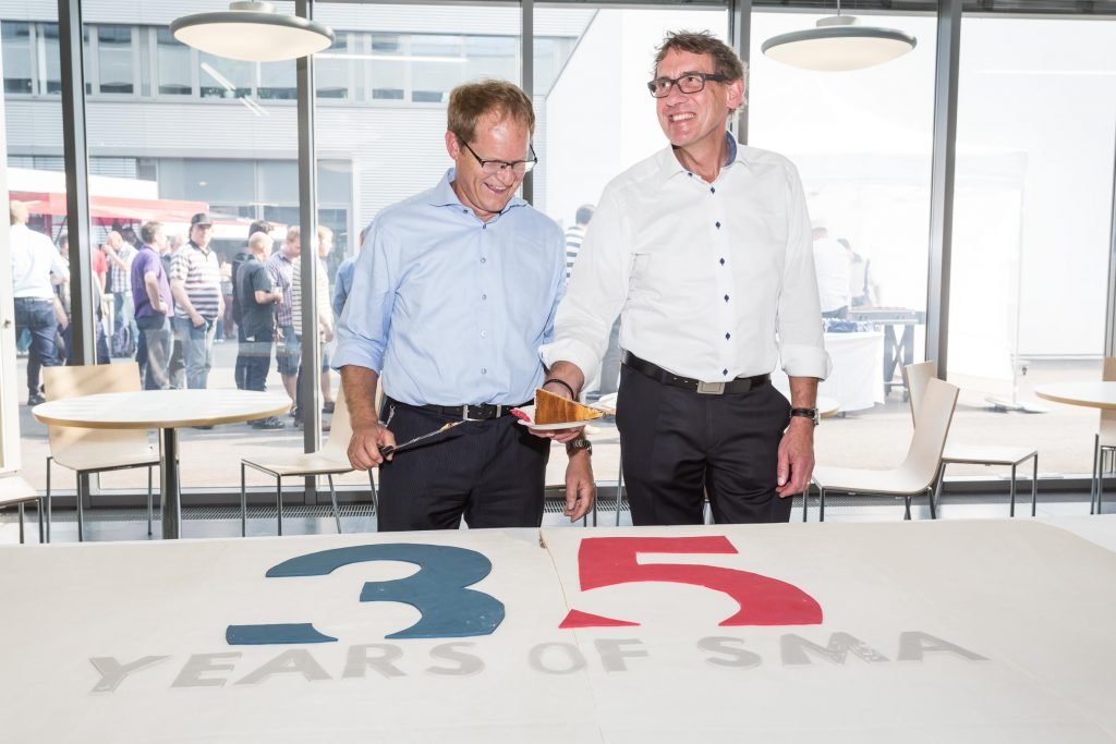 SMA Managing Board members Jürgen Reinert (left) and Roland Grebe cut the birthday cake.